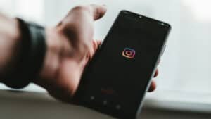 smartphone con display che mostra l'apertura dell'app Instagram