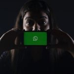 ragazza che esprime stupore con cellulare e schermata WhatsApp