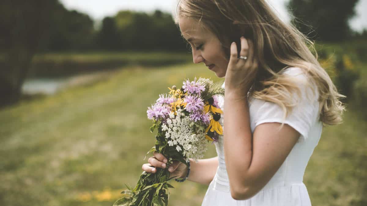 donna che riceve fiori a domicilio e ne sente il profumo