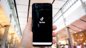 mano con smartphone che apre app TikTok mi piace