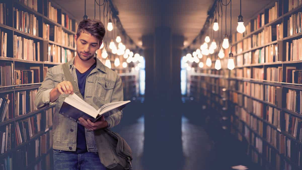 quale università fare studente con libro in mano corridoio libreria