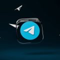 spoiler e reazioni chat di Telegram logo con aeroplani di carta sullo sfondo nero